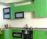 Зеленая угловая кухня с пленкой и стойкой под бакалы